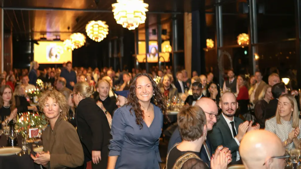 A packed function room with guests standing shoulder to shoulder