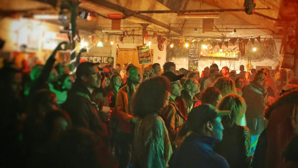 A densely packed bar crowd under coloured lighting