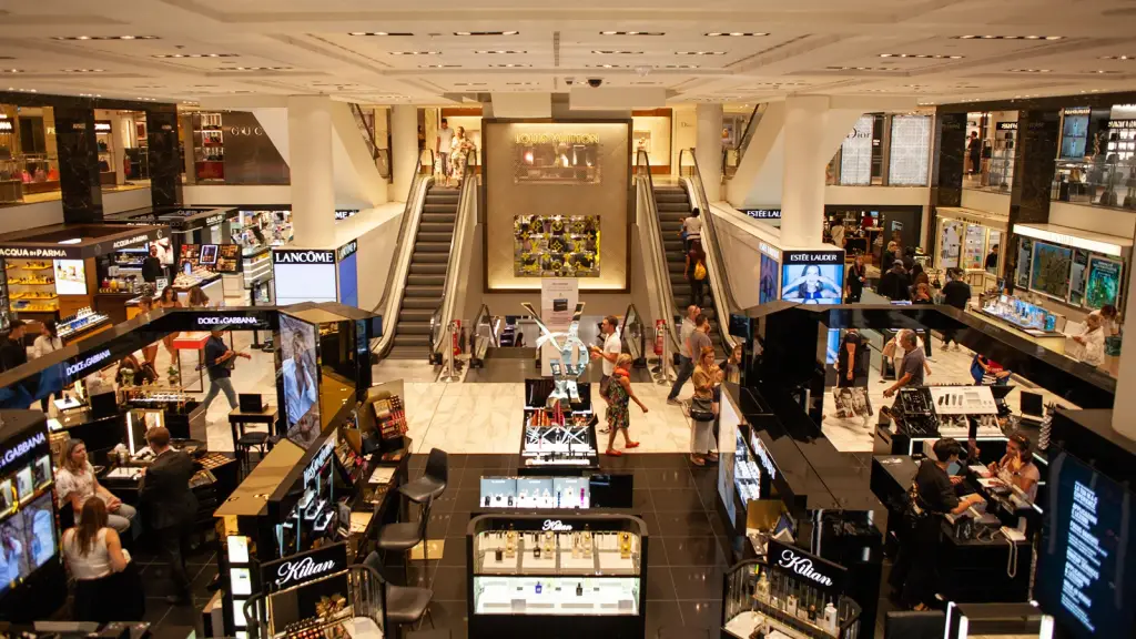 A busy shopping centre atrium with escalators and shopfronts