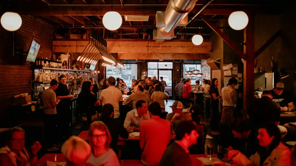 A busy pub interior with customers at tables and standing at the bar
